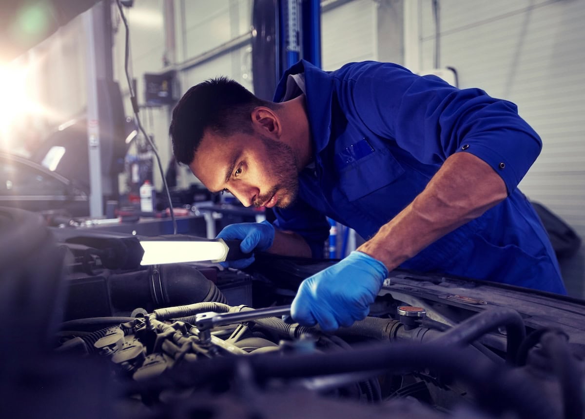 auto repair technician performing engine diagnostics in repair shop