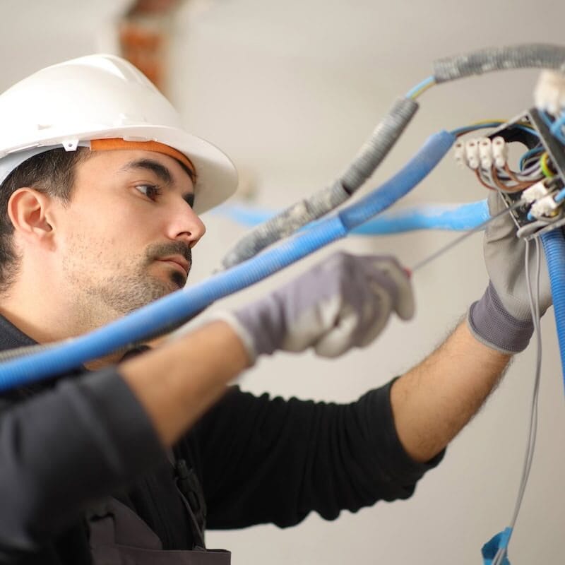 Licensed electrician repairing electrical wiring panel for local contractor service
