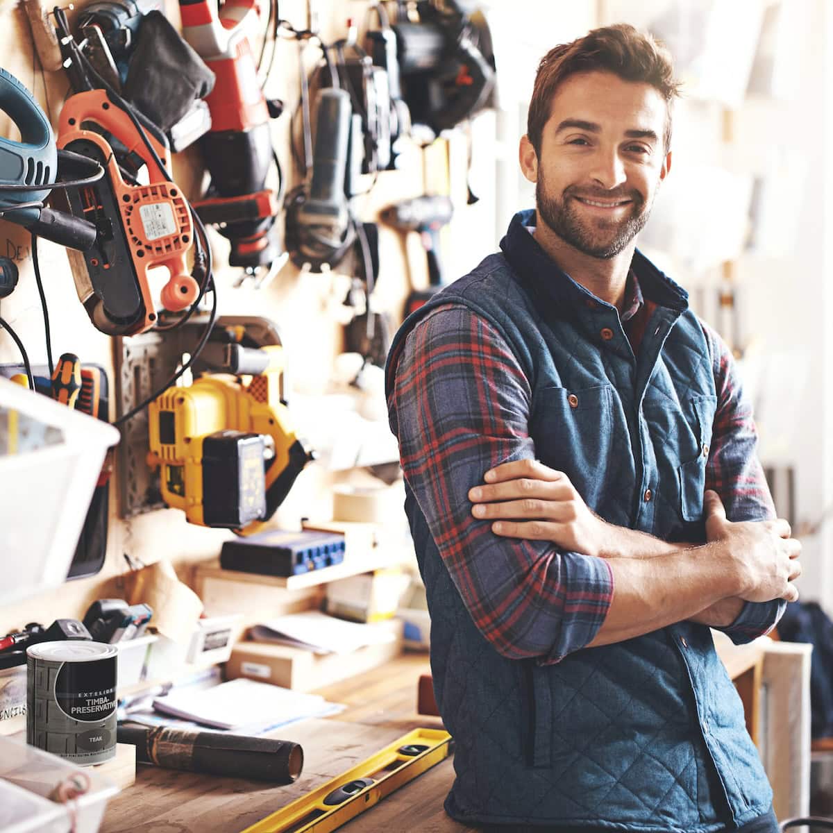 Confident trades contractor business owner standing in workshop representing local service industries